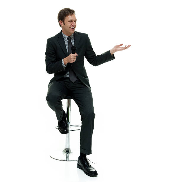 istock Smiling businessman presenting with microphone 614440516