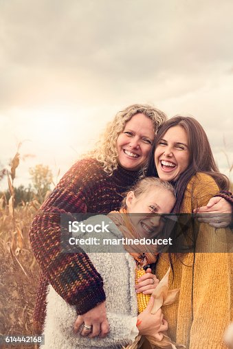 istock Portrait of teenagers with mother in autumn sunset outdoors. 614442168