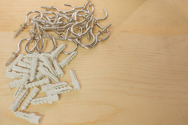istock Screw hooks and plastic anchors on the wood background. 614442366
