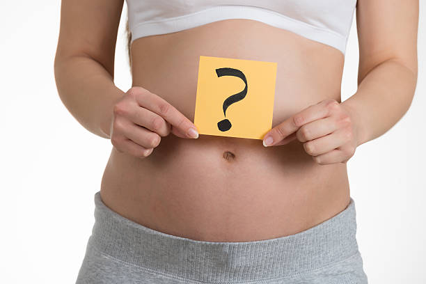 istock Pregnant Woman Holding Paper With Question Mark 614442814