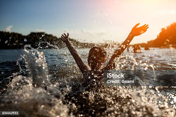 Little Kid Play In Water And Making Splash Stock Photo - Download Image Now - Lake, Swimming, Child