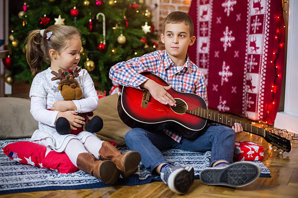 istock Brother playing guitar for his little sister 614445082