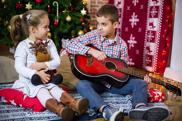 istock Brother playing guitar for his little sister 614445638
