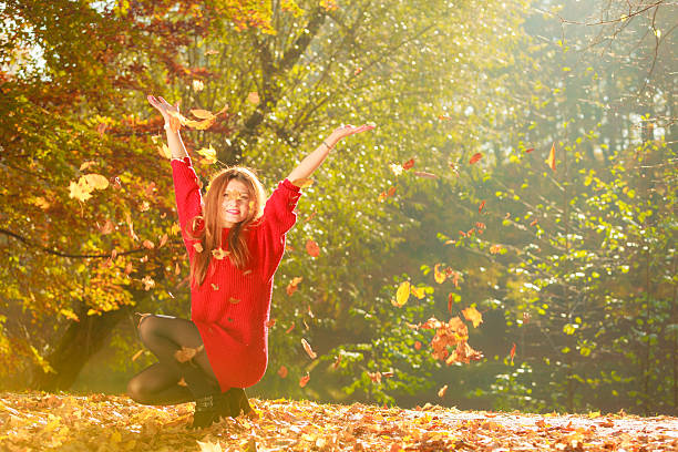 istock Crouching girl in autumnal forest. 614445912