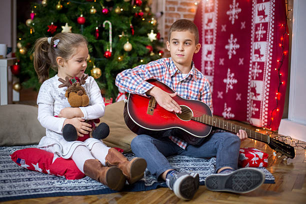 istock Brother playing guitar for his little sister 614446222
