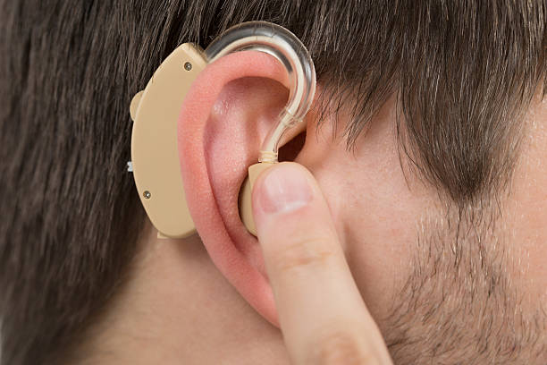 istock Man Wearing Hearing Aid In Ear 614446404