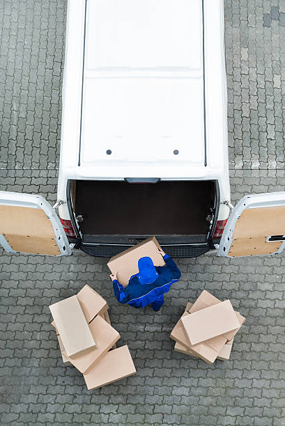 istock Delivery Man Unloading Cardboard Boxes From Van On Street 614446752