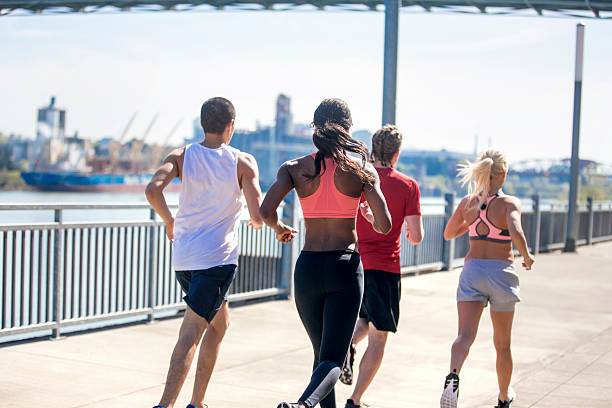 istock Diverse group of young adults running together 614446868