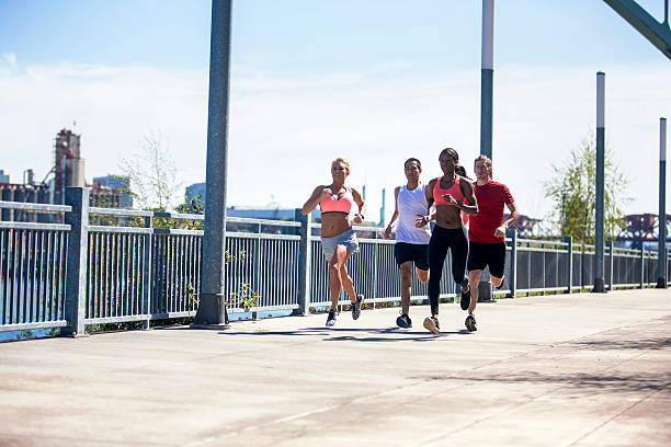 istock Co-Ed group of diverse young adults running 614446898