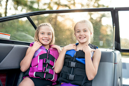 Young female siblings smile while wearing lifejackets