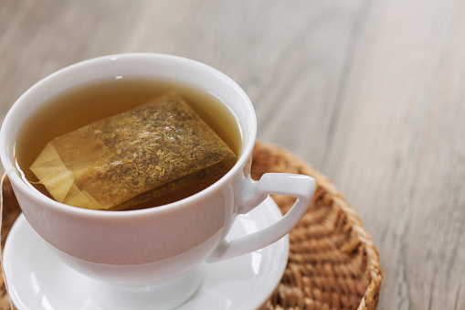 in a white cup flower tea made from medicinal plants and a teaspoon.