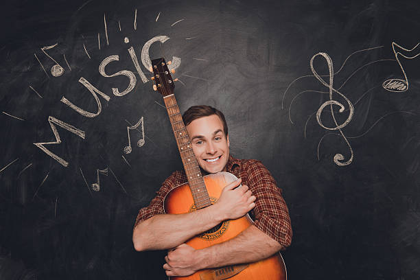 Strong man playing electric guitar in studio shot