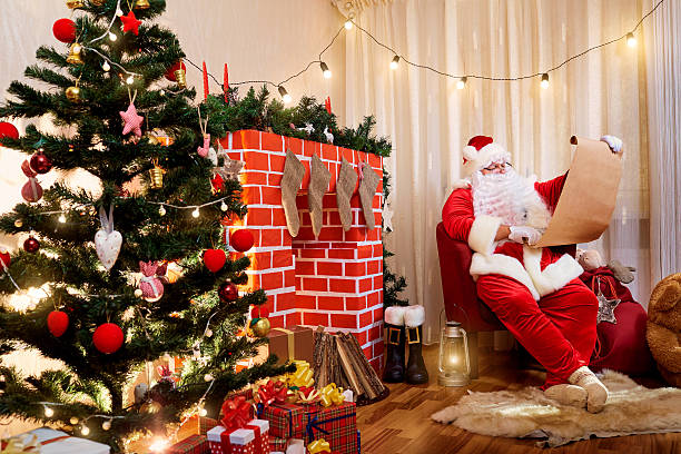 istock Santa Claus  Christmas list with a gift hands 614497056