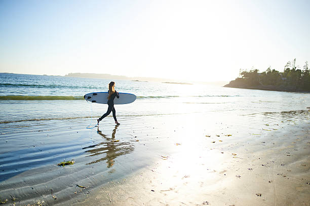 istock Strong beautiful young woman with surf on the beach 614498394