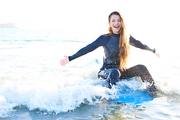 istock Strong beautiful young woman with surf on the beach 614500744