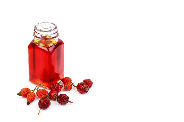 Bottle of rose hip oil on white background Bottle of rose hip oil on white background rose hip stock pictures, royalty-free photos & images