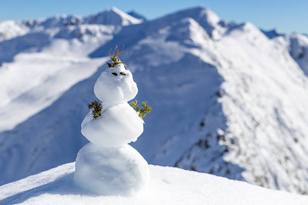 istock One little snowman on the top of mountains 614501464