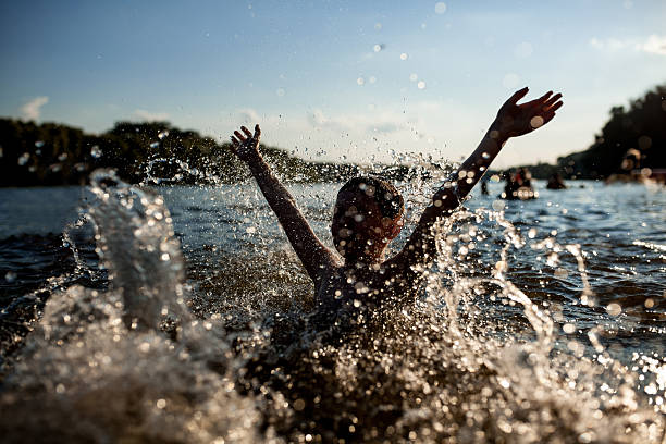 istock little kid play in water and making splash; 614503104