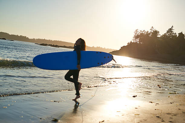 istock Strong beautiful young woman with surf on the beach 614503194