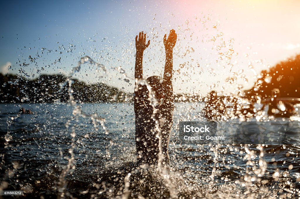 little kid play in water and making splash; child swim in lake or river and have fun with drops; River Stock Photo