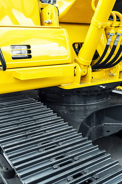istock gray tracks on a yellow excavator 614506128