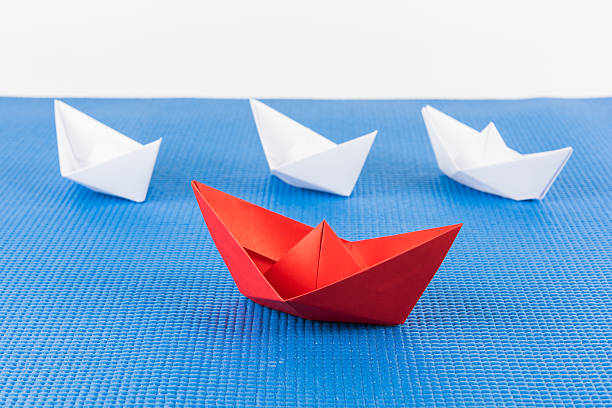 istock red paper ship leading among white 614506216