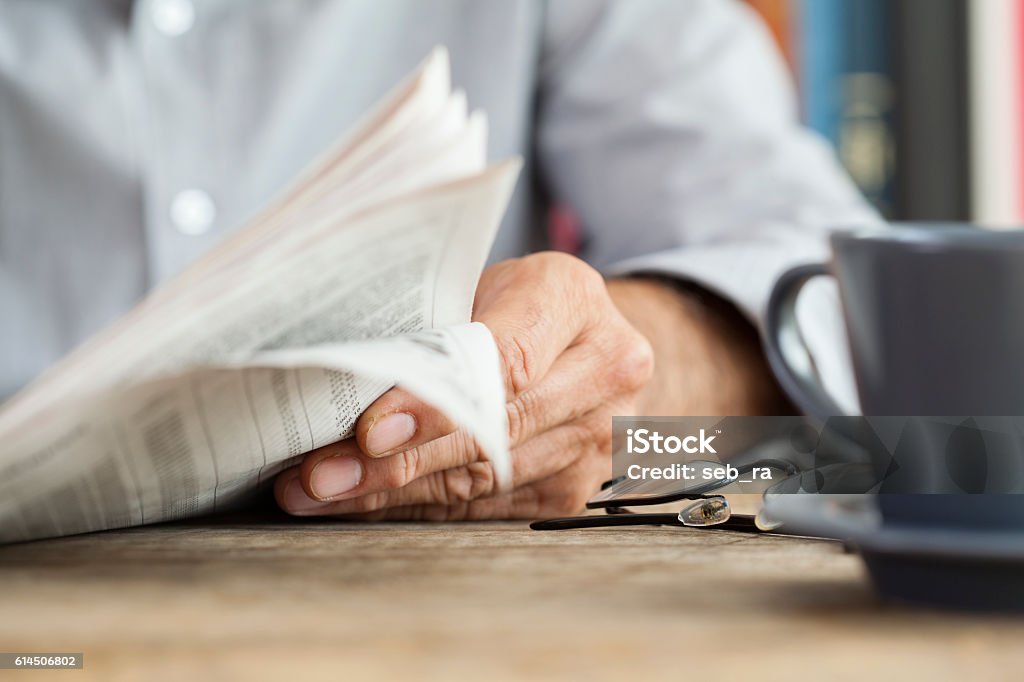 Man newspaper reading on table Newspaper Stock Photo