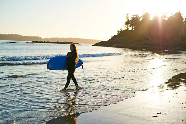 istock Strong beautiful young woman with surf on the beach 614508028