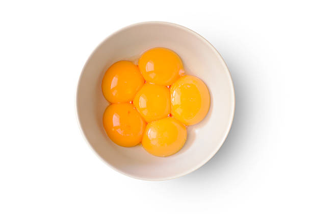 Egg yolks Six fresh and shiny yolks in a bowl on white background. egg yolk stock pictures, royalty-free photos & images