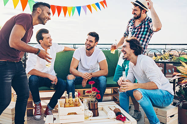 Boys drinking beer on the rooftop Group of young men drinking and laughing on a rooftop party. stag night stock pictures, royalty-free photos & images