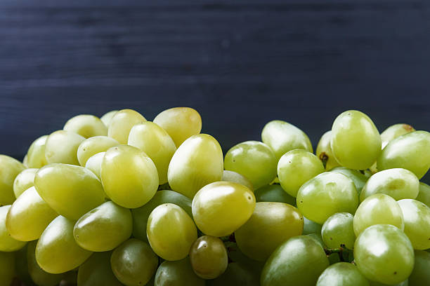istock Cluster ripe grapes at wooden board 614510328