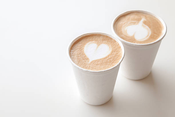 istock Two paper cups of coffee with heart shape latte art 614510518