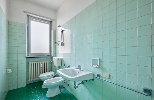 Old bathroom interior with green tiles in normal apartment
