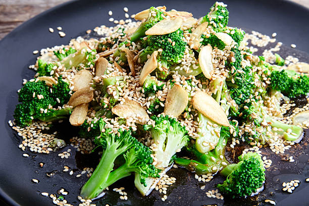 steamed broccoli with garlic chips and sesame seeds - asian cuisine close up garlic vegetable imagens e fotografias de stock