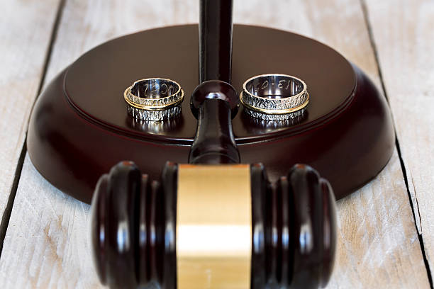 Divorce concept. Close up of wedding rings and judge gavel stock photo