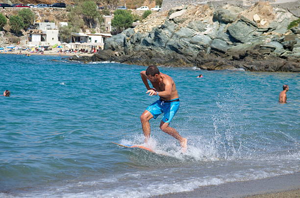 ギリシャのティノス島のビーチでのスキミングボード - skimboard ストックフォトと画像