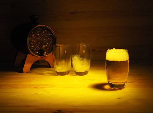 Barrel and glass of light beer on a wooden background