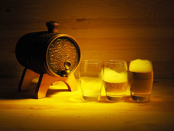 Barrel and glass of light beer on a wooden background