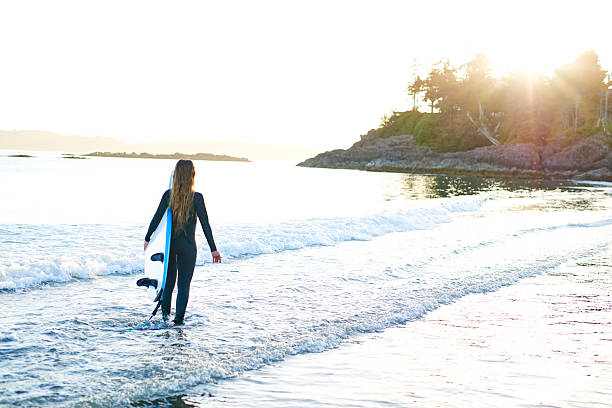 istock Strong beautiful young woman with surf on the beach 614512904