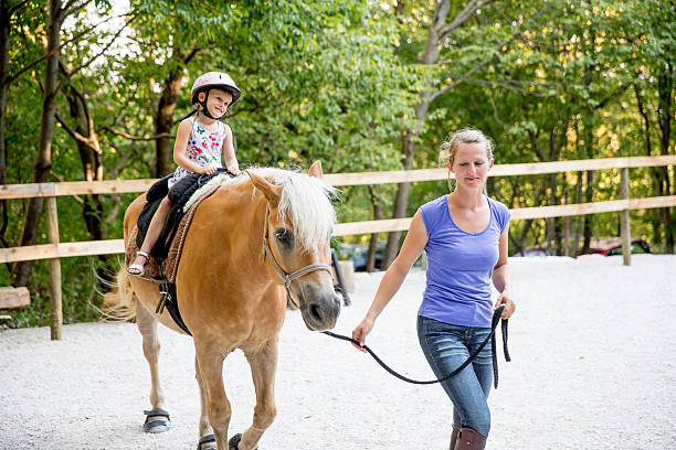 istock Little Girl Learning to Ride a Horse 614513256