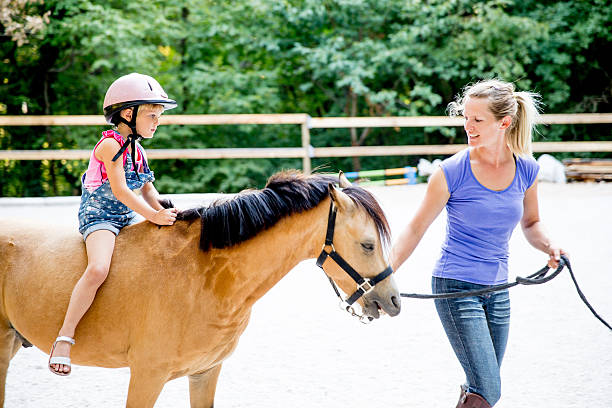 istock Little Girl Learning to Ride a Horse 614513280