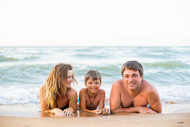 istock Family of three having fun at the beach 614513366