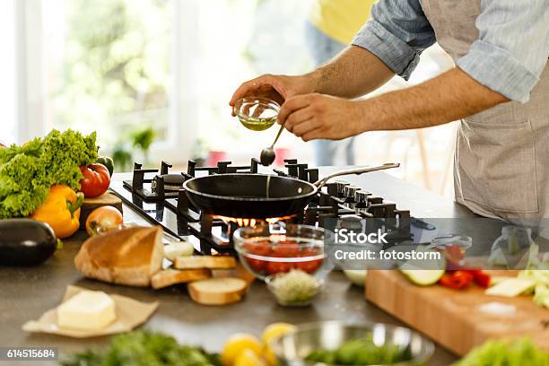 Man Pouring Cooking Oil Into Frying Pan Stock Photo - Download Image Now - Cooking Oil, Cooking, Frying Pan