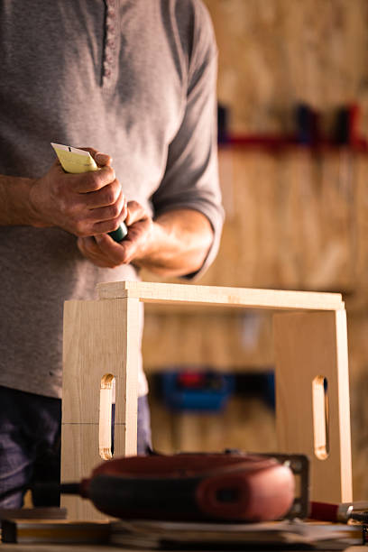 istock Carpenter gluing wood product in workshop 614517356