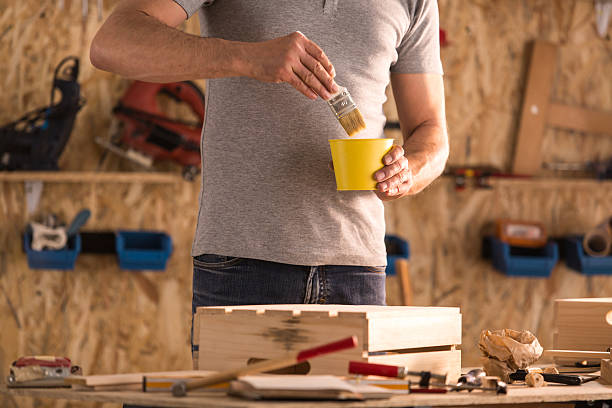 istock Carpenter painting wooden box in his workshop 614517576