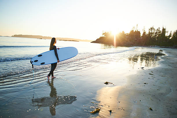 istock Strong beautiful young woman with surf on the beach 614519628
