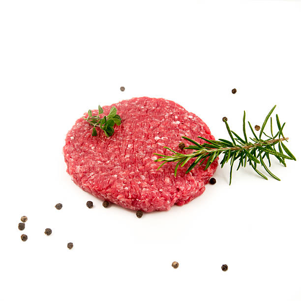 istock raw hamburger, rosemary and pepper on black background 614520534