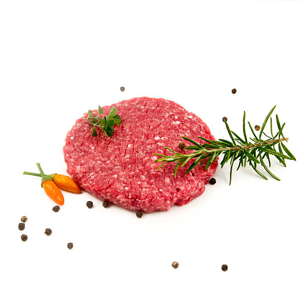 istock raw hamburger, rosemary and pepper on black background 614520604