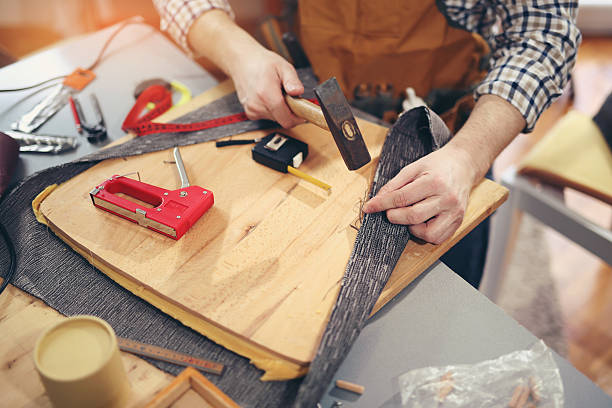 Man upholstering chair in his workshop Man upholstering chair in his workshop upholstered furniture stock pictures, royalty-free photos & images