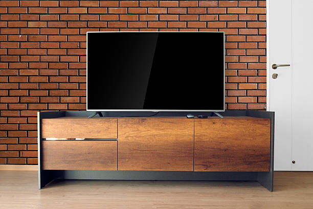 istock Led TV on stand in room with red brick wall 614525170